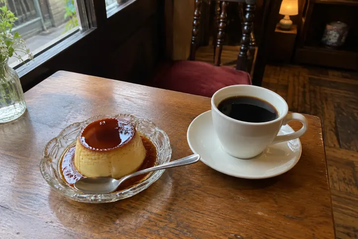 喫茶店の窓際のプリンとコーヒー